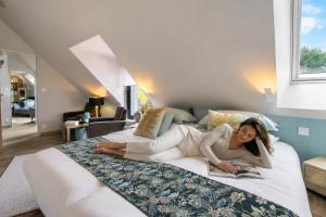 a woman laying on a bed reading a book at La Lézardière in Pleugriffet +22 photos