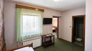 a room with a bed and a window and a table at Picikato Rooms in Krapina