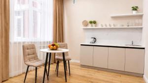 a kitchen with a table and two chairs and a sink at Студия ЖК "Кенесары" in Kokshetau +4 photos