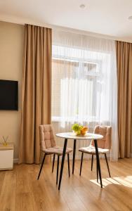 a dining room with a table and chairs and a window at Студия ЖК "Кенесары" in Kokshetau