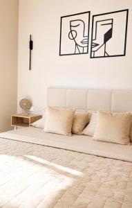a white bedroom with a bed with two pillows at Студия ЖК "Кенесары" in Kokshetau
