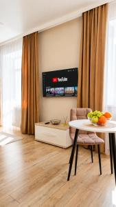 a living room with a table and a tv at Студия ЖК "Кенесары" in Kokshetau