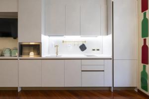a white kitchen with a sink and a microwave at CA' FORTE RESIDENCE in Venice +12 photos