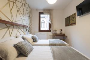 a bedroom with two beds and a tv on the wall at CA' FORTE RESIDENCE in Venice