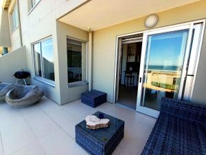 a balcony of a building with a view of the ocean at Sea Spray Table View Beachfront Bliss in Cape Town