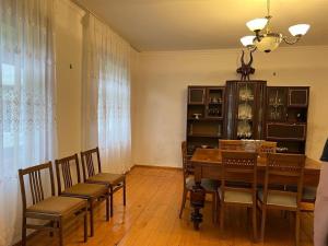 a dining room with a table and chairs and a chandelier at Lentexi Inn in Lentekhi