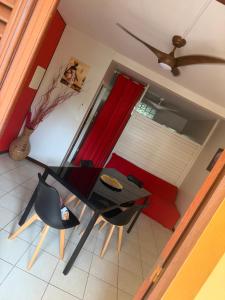 a dining room with a table and chairs and a window at Villa Boat red in Quartier Morne Acajou +2 photos