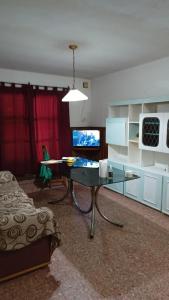 a living room with a glass table and a television at Monte Grande Hostel in Monte Grande