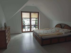 a bedroom with a bed and a dresser and a window at Guest house in Wojtkowa