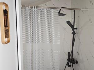 a shower with a white shower curtain in a bathroom at Zarati House  +22 photos