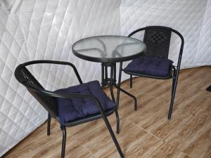 two chairs and a glass table and two chairs at Zarati House 