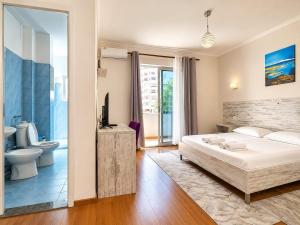 a bedroom with a large bed and a bathroom at Top view hostel in Durrës
