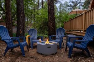 a group of blue chairs around a fire pit at Hotevilla A-Frame Cabin with Wi-Fi & Pine Tree Views in Flagstaff