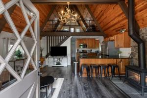 a kitchen and living room with a fireplace and a chandelier at Hotevilla A-Frame Cabin with Wi-Fi & Pine Tree Views in Flagstaff