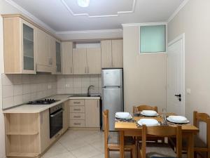 a kitchen with a table and chairs and a refrigerator at Daniels apartment in Shëngjin