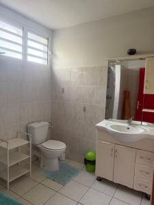 a bathroom with a toilet and a sink at Villa Boat red in Quartier Morne Acajou