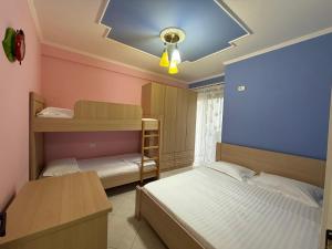 a bedroom with two beds and a blue wall at Daniels apartment in Shëngjin