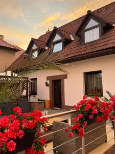 a house with red flowers on the balcony at Apart Samont in Velký Ořechov