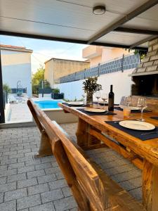 a wooden table with a bottle of wine and glasses at Apartments Antini in Solin