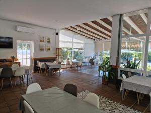 a restaurant with tables and chairs and windows at Hotel Marisma Sancti Petri in Chiclana de la Frontera
