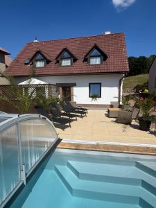 a house with a swimming pool in front of a house at Apart Samont in Velký Ořechov