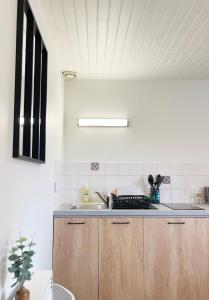 a kitchen with wooden cabinets and a sink at Petite escapade dans le Perche 1 in Sainte-Céronne-lès-Mortagne