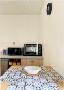 a kitchen with a microwave and a bowl on a table at Petite escapade dans le Perche 1 in Sainte-Céronne-lès-Mortagne