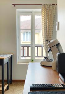 a office with a microscope on a desk with a window at Petite escapade dans le Perche 1 in Sainte-Céronne-lès-Mortagne