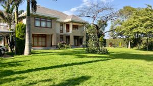 a house with a large yard with green grass at Uyoga House in Arusha