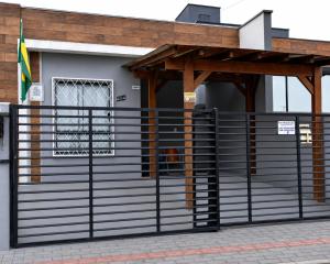 a gate to a building with a wooden roof at Suíte Completa in Barra Velha