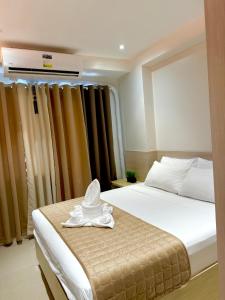 a hotel room with a bed with a hat on it at Shell Residences Condotel near Mall of Asia - Aiza's Place in Manila +15 photos