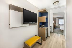 a room with a flat screen tv on a wall at Comfort Suites Albuquerque-North Journal Center in Albuquerque