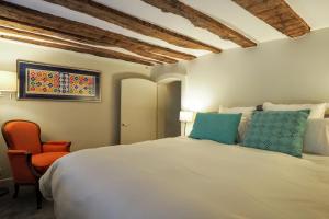 a bedroom with a large bed and a chair at Molière ChicSuites in Paris