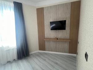 a room with a flat screen tv on a wall at Fortuna Hotel in Batumi