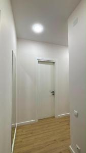 an empty room with a white door and a wooden floor at next green in Makhinjauri
