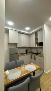 a kitchen with a wooden table and chairs at next green in Makhinjauri