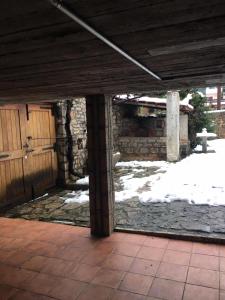 an outdoor patio with a stone fireplace and snow at Ξενώνας Το Πάλαι Ποτέ in Polydrossos +4 photos