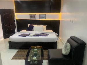 a bedroom with a bed and a chair and a couch at ffa resort centre in Akure +16 photos