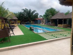 a swimming pool with green grass and a playground at ffa resort centre in Akure