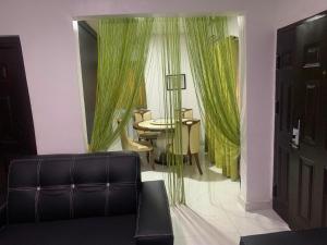 a living room with green curtains and a table at ffa resort centre in Akure