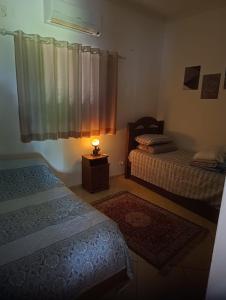 a bedroom with two beds and a lamp on a table at Rancho do Mirante in Araçatuba +21 photos