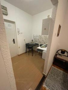 a small room with a small table and a kitchen at Аpartman CACA in Pančevo