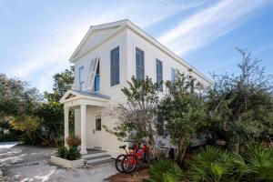 a red bike parked in front of a white house at Magnolia Honeymoon Cottage in Santa Rosa Beach