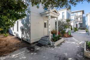 a tiny house with a porch on a street at Magnolia Honeymoon Cottage in Santa Rosa Beach