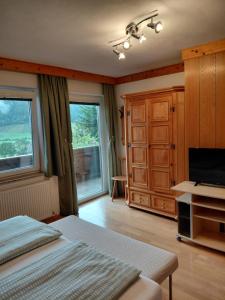 a bedroom with a bed and a flat screen tv at Apartment Haus Dengg in Mauterndorf