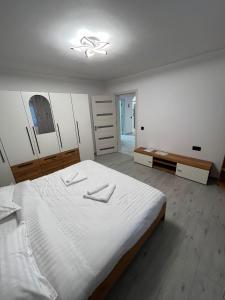 a bedroom with a large white bed in a room at Căsuța Găvruj in Săcel