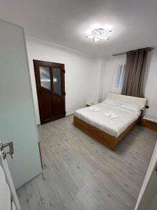 a bedroom with a bed and a wooden floor at Căsuța Găvruj in Săcel
