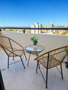 a glass table and two chairs on a balcony at LA RIVIERA María II - CON COCHERA in Villa María
