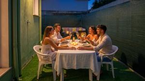 a group of people sitting around a table with wine glasses at In DhomeU Tua - Free Wifi & Private Garden in Selargius