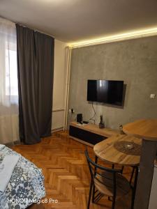 a room with a table and a television on the wall at Niški kutak in Niš